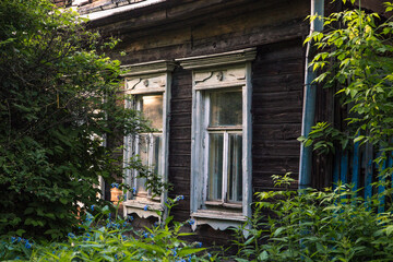 Fototapeta na wymiar Old wooden house. Windows and bushes