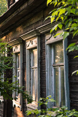 Old wooden house. Windows and bushes