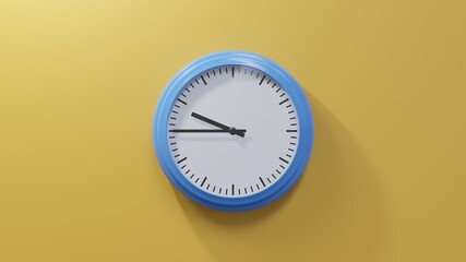 Glossy blue clock on a orange wall at quarter to ten. Time is 09:45 or 21:45