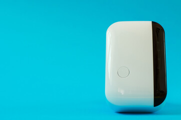 Wireless wifi repeater on a blue background close-up. The concept of modern wireless technologies.