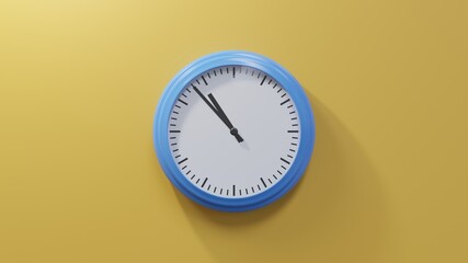 Glossy blue clock on a orange wall at fifty-three past ten. Time is 10:53 or 22:53