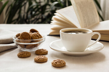 Still life with a Cup of coffee, cookies and a book. The atmosphere of a cozy morning Breakfast at home or in a cafe.