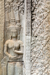 Fototapeta na wymiar Beautiful bas-relief in Angkor wat temple in Cambodia, representing dancing apsara - female spirit popular in 12th century Cambodia.