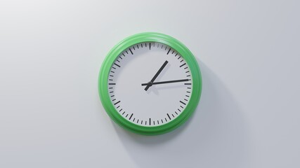 Glossy green clock on a white wall at fourteen past one. Time is 01:14 or 13:14