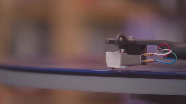 Spinning and lifting stylus off of a blue vinyl lp extreme close up