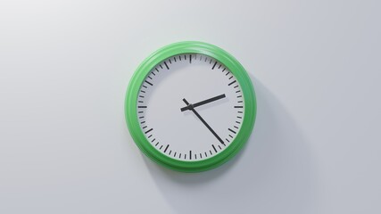 Glossy green clock on a white wall at twenty-three past two. Time is 02:23 or 14:23