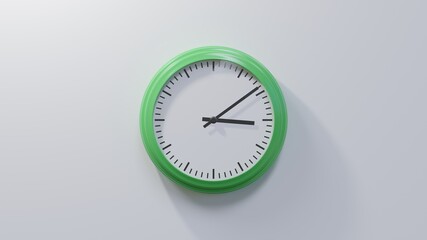 Glossy green clock on a white wall at nine past three. Time is 03:09 or 15:09