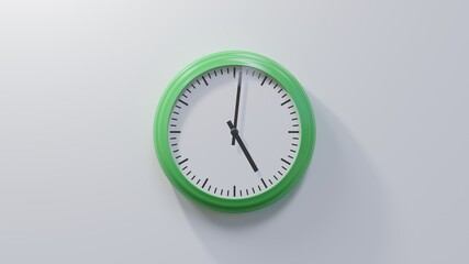 Glossy green clock on a white wall at one past five. Time is 05:01 or 17:01