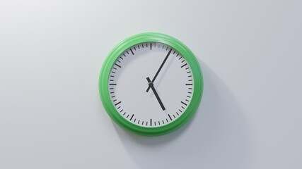 Glossy green clock on a white wall at five past five. Time is 05:05 or 17:05