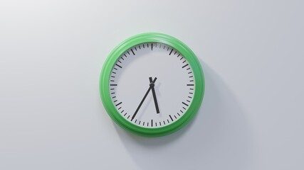 Glossy green clock on a white wall at thirty-five past five. Time is 05:35 or 17:35