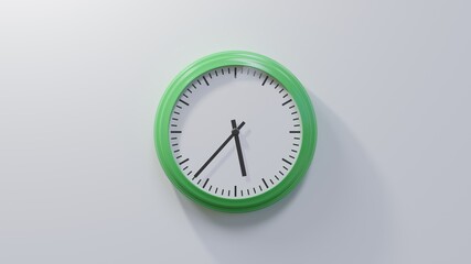 Glossy green clock on a white wall at thirty-seven past five. Time is 05:37 or 17:37