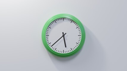 Glossy green clock on a white wall at thirty-eight past five. Time is 05:38 or 17:38