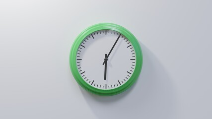 Glossy green clock on a white wall at five past six. Time is 06:05 or 18:05