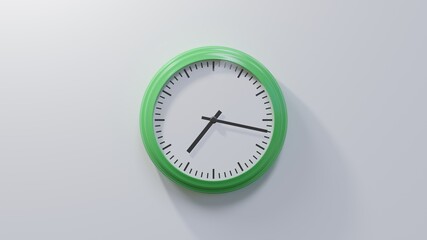 Glossy green clock on a white wall at seventeen past seven. Time is 07:17 or 19:17