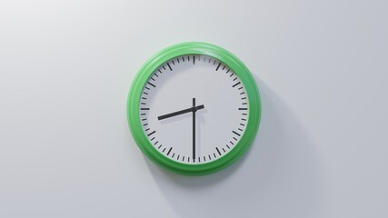 Glossy green clock on a white wall at half past eight. Time is 08:30 or 20:30