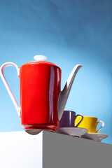 Red coffee teapot and two cup for coffee shop stand on a white cube