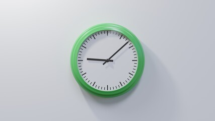 Glossy green clock on a white wall at eight past nine. Time is 09:08 or 21:08