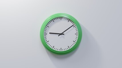 Glossy green clock on a white wall at nine past nine. Time is 09:09 or 21:09