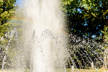 Selective focus on spray of urban fountain and blurred background