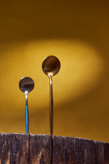 Golden Spoons standing on wooden frame. yellow background