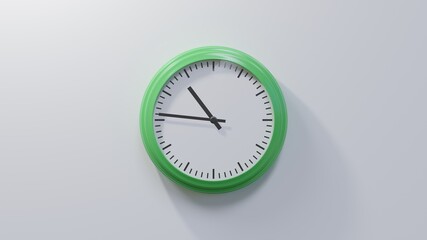 Glossy green clock on a white wall at forty-six past ten. Time is 10:46 or 22:46