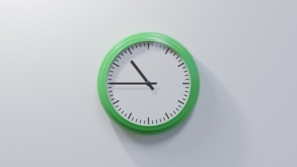 Glossy green clock on a white wall at quarter to eleven. Time is 10:45 or 22:45