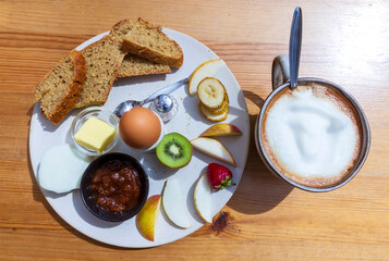 Health vegetarian breakfast : homemade ray fresh bread, egg, fruits, jam, butter and huge cup of coffee. 