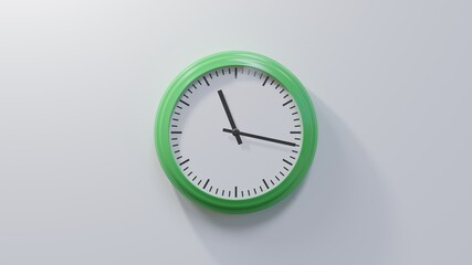 Glossy green clock on a white wall at seventeen past eleven. Time is 11:17 or 23:17