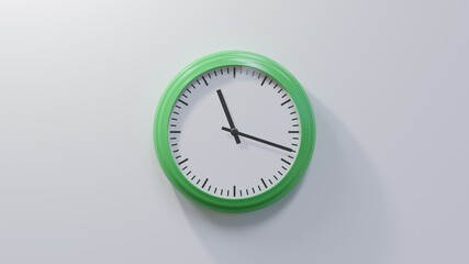 Glossy green clock on a white wall at eighteen past eleven. Time is 11:18 or 23:18