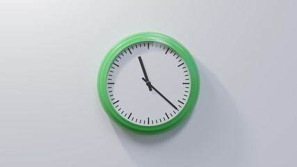 Glossy green clock on a white wall at twenty-two past eleven. Time is 11:22 or 23:22