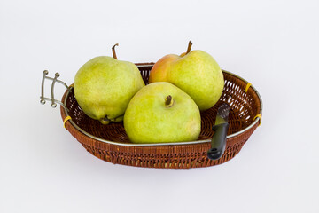 Three,fresh pears in brown color,wicker basket with knife on white with copy space