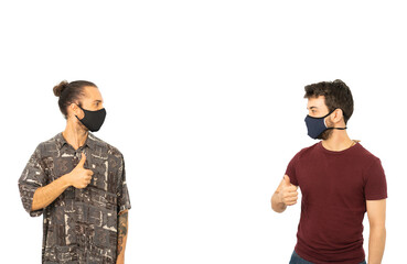 Amigos con ropa informal y mascarilla manteniendo la distancia de seguridad contra el coronavirus...