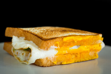 Homemade sandwich concept. Grill two bread with a fried egg on a white plate with copy space.