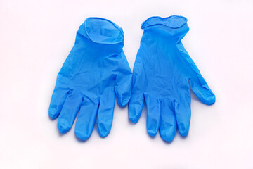 Pair of medical blue latex protective gloves on white background. Protective disposable gloves against the spread of virus, flu, coronavirus (COVID-19), bacterial. Health care and surgical concept.