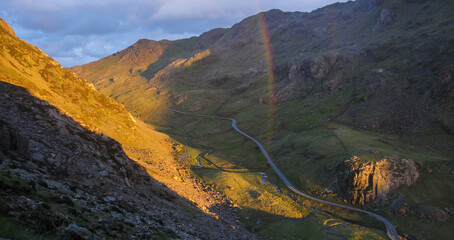 Scenic view of Llanberis Pass with rainbow