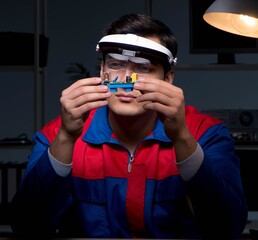 Computer specialist repairing PC late at night