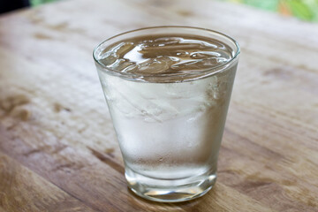 water with ice cubes on wooden table