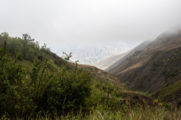 Beautiful mountains against cloudy sky. Green grassy valley. Nature of Norway. Mountain landscape against the sky in cloudy weather. Mountain landscape against a green field