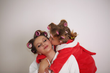 Photo of mother and daughter in white coats. They are sitting on the couch