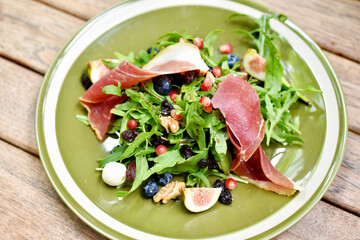 Rocket salad with prosciutto parma ham and berries fruit, Healthy diet food full of good vegetable...