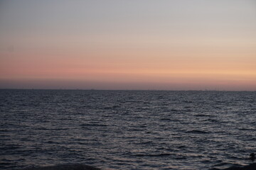 Obraz premium orange sunset, dark, still water, perfectly straight horizontal line, evening
