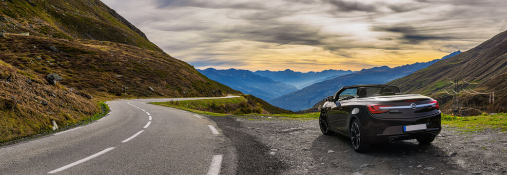 opel cascada convertible on a mountain pass road before sunset