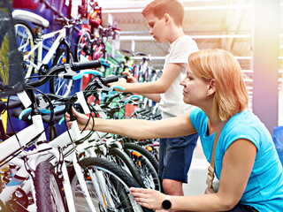Boy and mom choose bike in sport store
