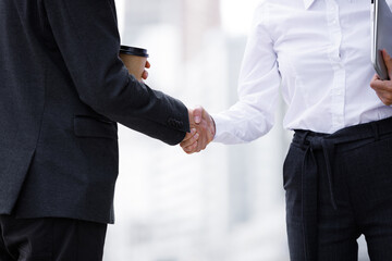 Success concept in business - handshake of partners. Handshake men in a suit and girls in a white...