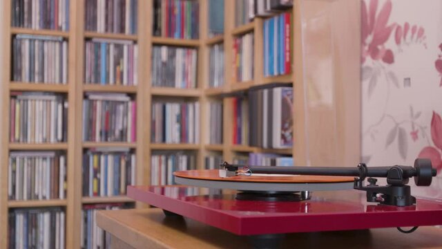 Stopping an orange vinyl lp on a record player and removing stylus close up