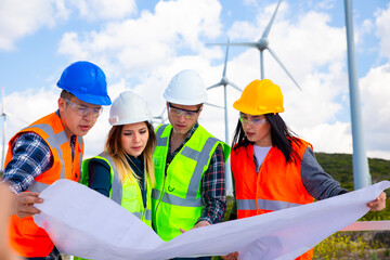 Young engineers and workers having a meeting at wind farm