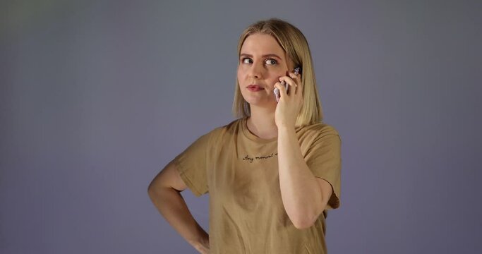 Eine h&uuml;bsche Blondine telefoniert mit Handy. Pl&ouml;tzlich wird sie sauer und gereizt, weil jemand sie st&ouml;rt und ablenkt.