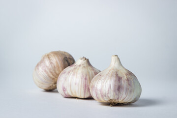 Garlic on a white background. Three garlic in the middle of the frame. Agriculture concept