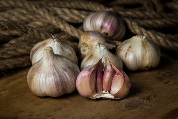 Garlic. A bunch of garlic lies on a wooden cutting board. Jute rope in the background. Agriculture concept
