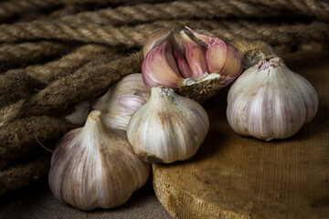 Garlic. A bunch of garlic lies on a wooden cutting board. Jute rope in the background. Agriculture concept